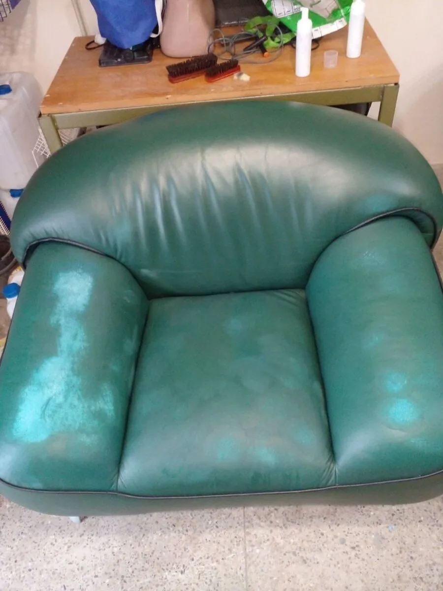 Worn green leather armchair before restoration