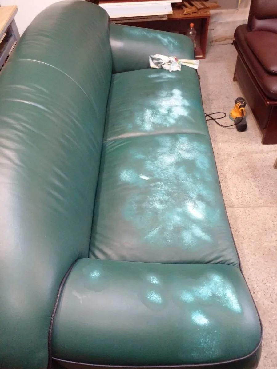 Worn green leather sofa before restoration